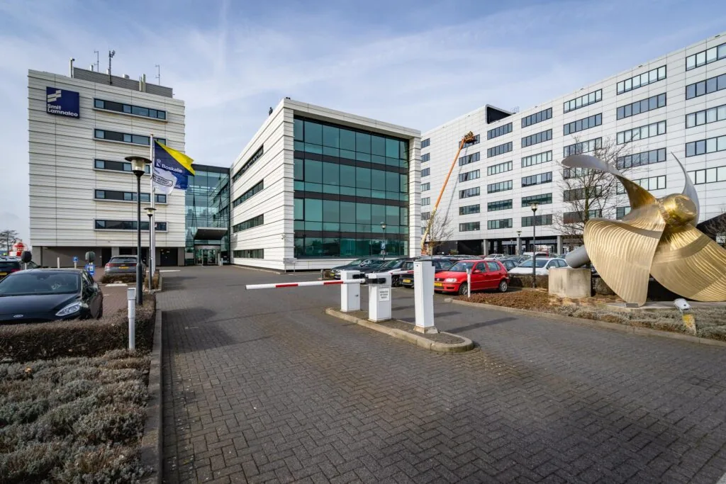 Bedrijfsgebouwen van Smit Lamnalco en Boskalis aan de Waalhaven met een grote scheepsschroef als kunstobject op de voorgrond.